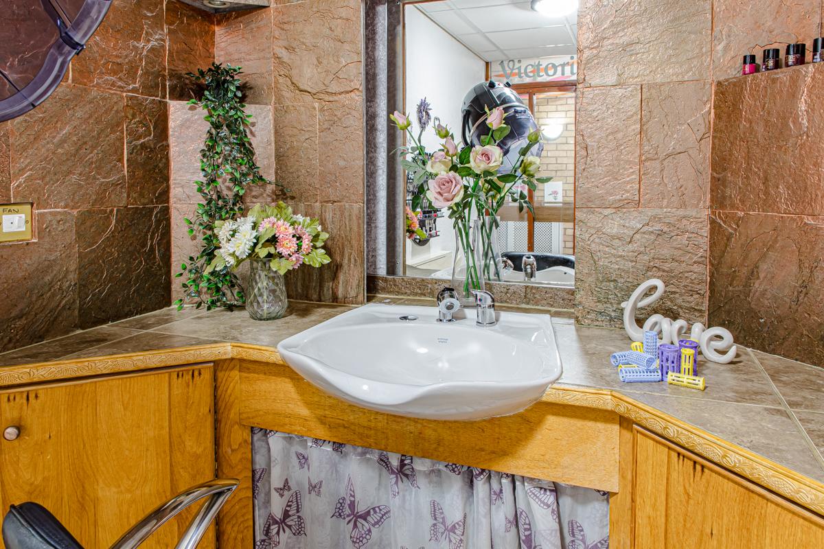 hair salon with white sink and flowers